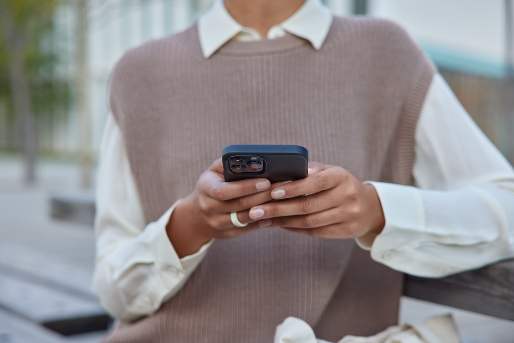 zensina-v-elegantnoi-odezde-derzit-mobil-nyi-telefon-serfit-po-besprovodnomu-internetu-delaet-pokupki-v-internete-sidit-na-skameike-na-ulice-podklucena-k-besprovodnomu-internetu-obsaetsa-distancionno.jpg